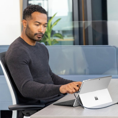 A person sitting at a table with a tablet.