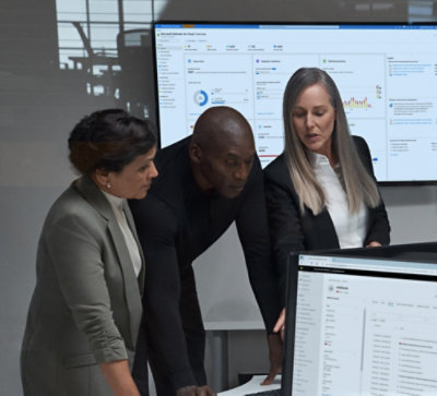 A group of people gathered around a computer screen.