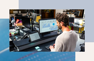 Una persona seduta alla scrivania che guarda lo schermo di un computer.