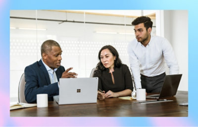 Tre persone che discutono con un portatile aperto