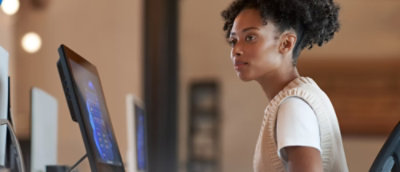 Una persona con una camicia bianca che guarda lo schermo di un computer.