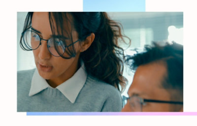 Due persone in un'area di lavoro, una con occhiali e un maglione con colletto